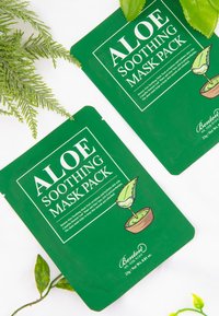Confezione verde per il Maschera Lenitiva all'Aloe, con un'illustrazione di piante, testo bianco e un design semplice. Sono mostrati due pacchetti.