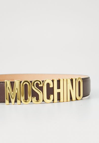 Brun lærrem med store, fet gullbokstaver som staver "MOSCHINO" som en fremtredende spenne detalj. Glatt tekstur med stilrent design.
