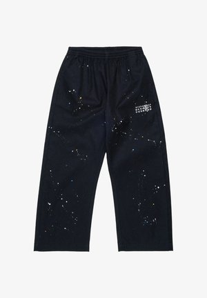 Schwarze Hose mit weitem Bein und elastischem Bund, mit weißem, blauem und gelbem Farbspritz-Design sowie weißen, aufgedruckten Zahlen am rechten Oberschenkel.