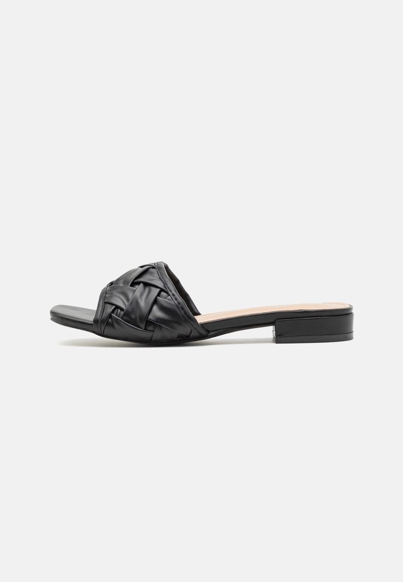 Black slide sandal with woven leather strap, low block heel, and square toe on white background.