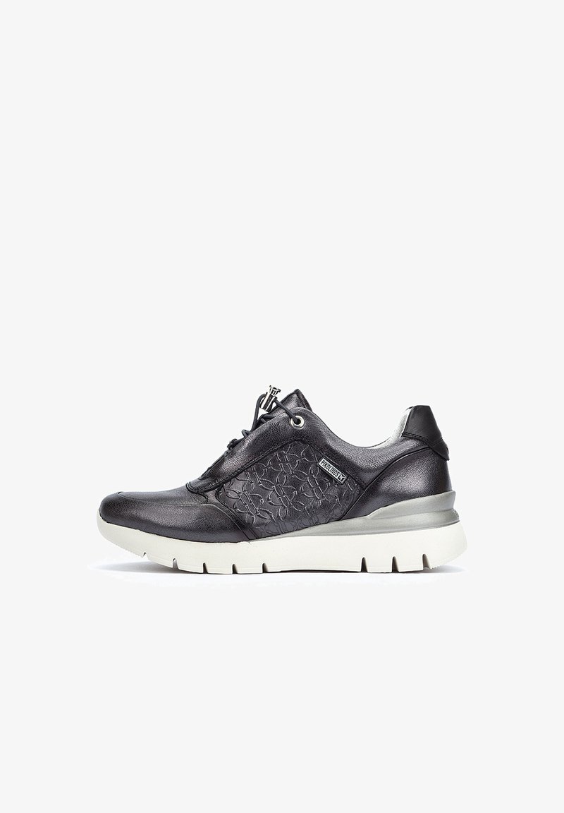 Zapatilla de deporte de cuero negro con panel lateral texturizado, diseño con cordones, suela acolchada y una suela exterior clara en contraste.