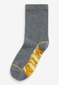 Graue Socke mit geripptem Bündchen, die ein gelb- und orangefarbenes Tarnmuster an der Seite und einen einfarbigen gelben Akzent an der Zehe aufweist.