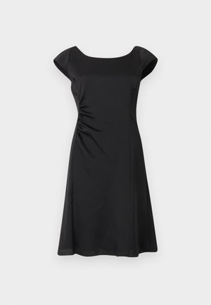 Robe noire mi-longue aux genoux avec manches courtes, un large décolleté et de légers plis froncés sur le côté gauche de la taille.