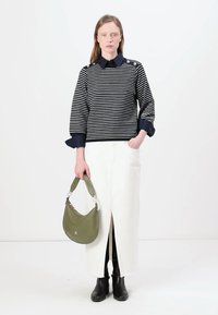 Pulover în dungi albastre și albe cu guler, asortat cu o fustă albă cu o deschidere frontală. Modelul poartă o poșetă verde măsliniu. Botine negre.