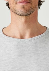 T-shirt in cotone grigio con scollatura ampia e rotonda e una sottile trama, che mette in risalto un design aderente. Tessuto liscio con dettagli di cucitura minimi.