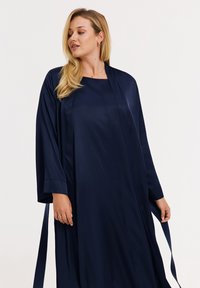 Marineblauwe satijnen badjas met lange mouwen, voorzien van een rechte snit en taillebanden voor verstelbaarheid. Gladde textuur en elegant ontwerp.