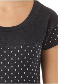 Granatowa bawełniana koszulka z okrągłym dekoltem, krótkimi rękawami i wzorem w białe kropki. Miękka tekstura z kontrastowym, warstwowym wykończeniem kołnierza.