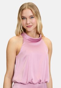 Mouwloze lichtroze top met een col-nek en textuurstof, met een ontspannen pasvorm en elastische zoom.