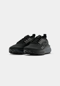 Black athletic shoes with a breathable mesh upper, padded collar, textured rubber outsole, and reflective accents on the side.