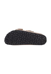 Sort gummisål med et bølgete mønster, beige overdel med justerbare stropper, flad design, velegnet til komfort og stabilitet.
