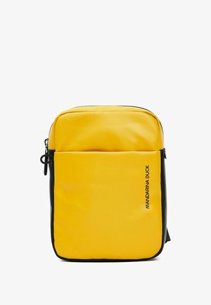Sac à dos synthétique jaune avec une finition texturée, accents noirs, poche avant zippée et nom de la marque imprimé sur le côté.