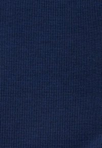 Tessuto rigato di colore navy con superficie testurizzata, caratterizzato da un motivo coerente di linee verticali e un aspetto morbido e intrecciato.