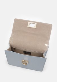 Světle modrá kožená kabelka s texturovaným povrchem, zlatými doplňky a měkkou béžovou podšívkou. Obsahuje vnitřní kapsu na zip.