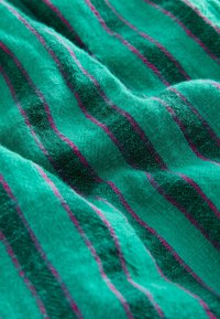 Tissu turquoise avec des rayures verticales fines rose pâle et vert foncé, présenté en gros plan avec une texture visible et de légers plis.