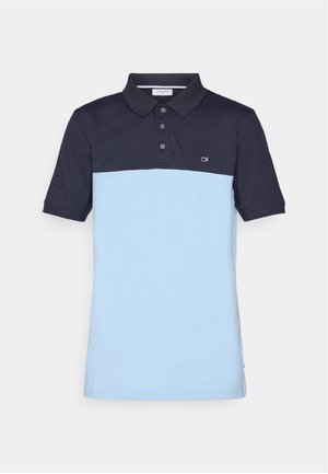 Polo skjorte med et design i marine og lyseblå fargeblokker, laget av teksturert bomull, med tre knapper og CK-logo på brystet.