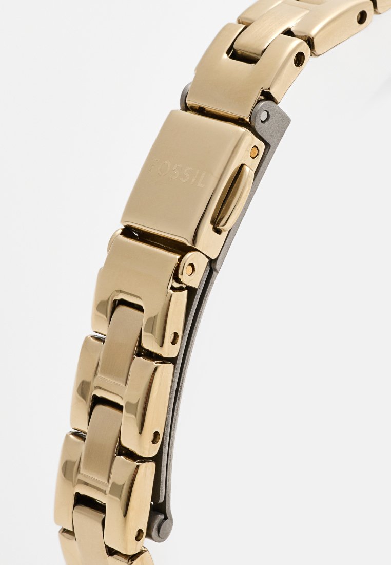 Bracelet de montre en métal doré avec une finition polie, comportant des maillons entrelacés et un fermoir à rabat pour une fermeture sécurisée.