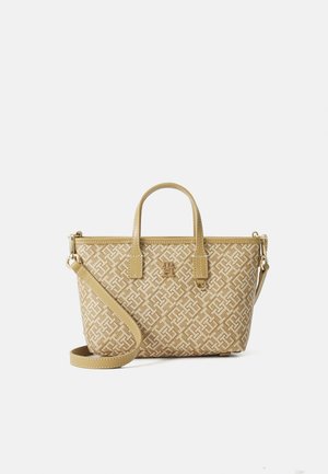 Sac à main beige à motifs, avec deux poignées, une bandoulière amovible, et un petit emblème logo au centre avant.