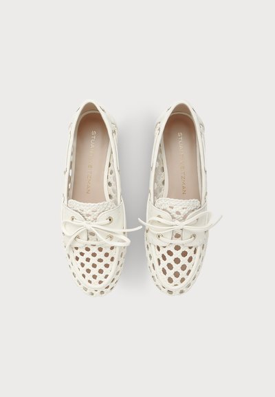 Paire de chaussures bateau en cuir blanc tressé avec lacets et design perforé, vues de dessus sur un fond neutre.