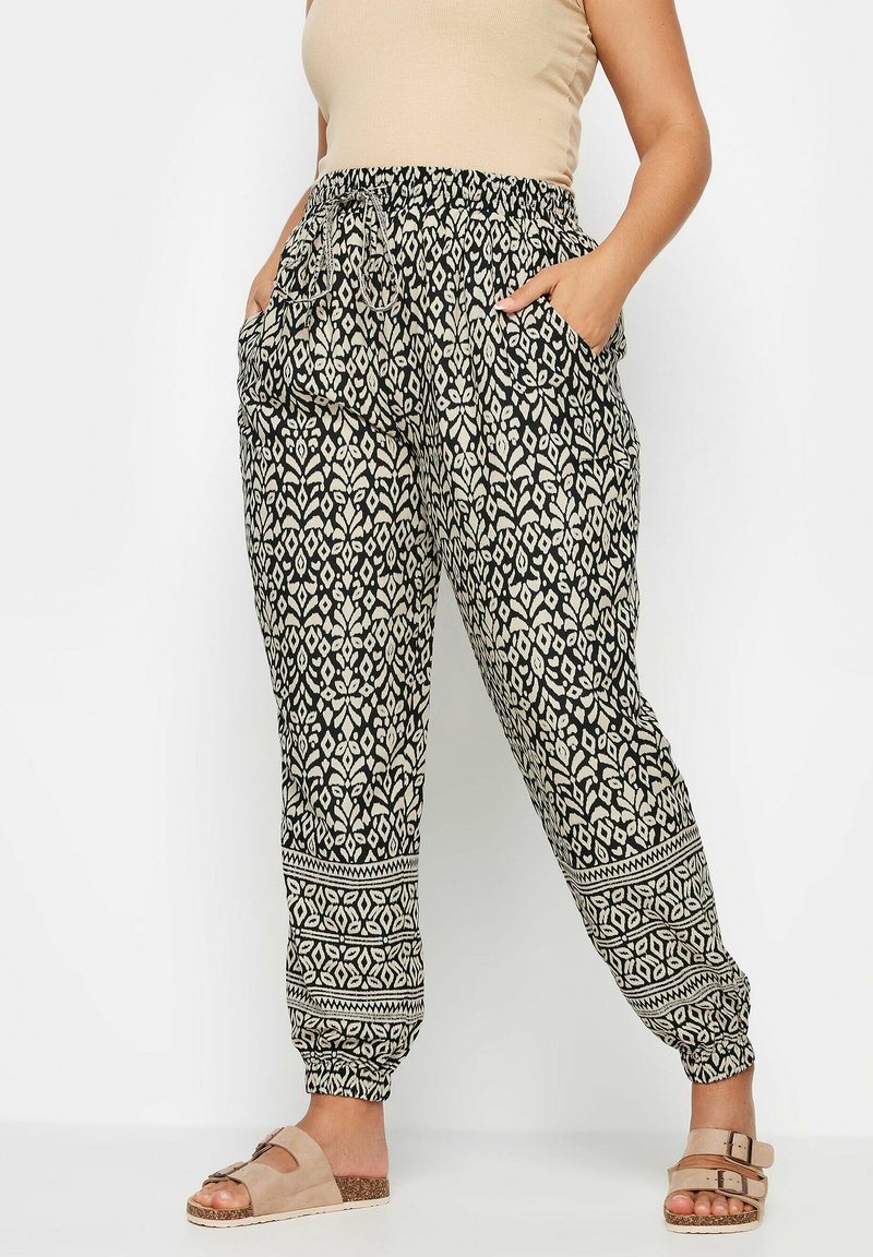 Svarta och beige mönstrade joggerbyxor med elastisk midja, sidofickor och avsmalnande mudd med geometrisk tryckdesign.