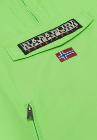 Giacca a vento verde brillante con patch del logo nero e bandiera norvegese ricamata, dotata di tasca con zip e texture liscia.