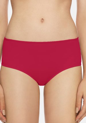 Donna che indossa biancheria intima rossa semplice e senza cuciture a vita alta, mostrando la sezione centrale dal punto vita alla parte superiore delle cosce.