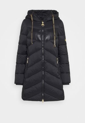 Manteau long matelassé noir avec capuche, fermeture éclair dorée, poches latérales zippées et cordons noirs avec texte doré et embouts métalliques.