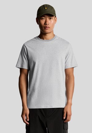 Grijze katoenen t-shirt met korte mouwen en ronde hals. Glad textuur en een relaxte pasvorm. Gdragen met een donkere pet met geborduurd logo.