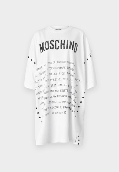 Fehér, túlméretezett póló fekete szöveggel, a "MOSCHINO" szó vastag betűkkel szerepel rajta. Fekete pöttyös díszítés található az ujjak és az oldalsó varrás mentén.