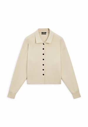 Béžový pletený kardigan s límcem košile a černými knoflíky vpředu, s dlouhými rukávy a žebrovanými manžetami.