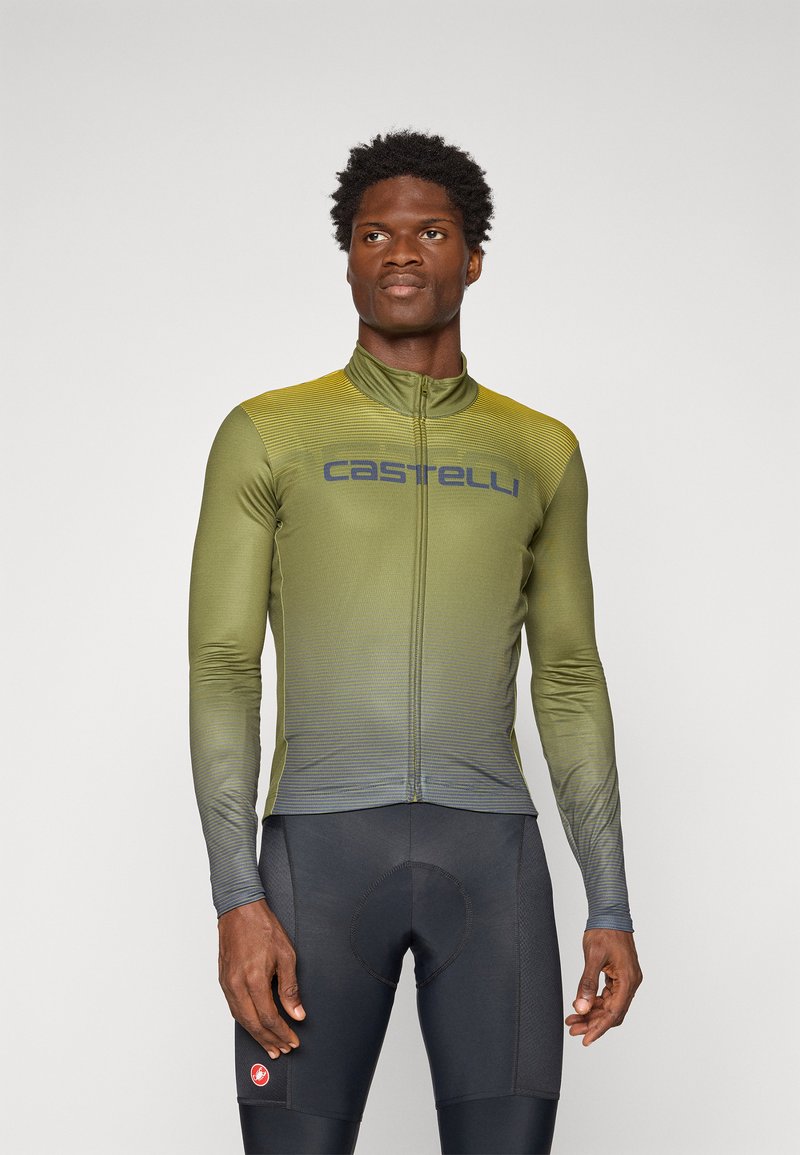 Zielony gradientowy rowerowy jersey z długim rękawem i zamkiem błyskawicznym z przodu, z poziomymi paskami i logo "Castelli" w ciemnoniebieskim kolorze. Czarne szorty rowerowe.