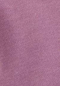 Tessuto lavorato a maglia in un morbido colore lavanda. Presenta una trama fine con un motivo uniforme, mostrando una leggera elasticità e una sensazione di leggerezza.