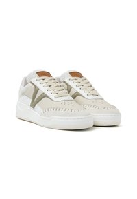 Beige sneakers with a textured suede upper, mesh tongue, and white rubber sole. Features contrasting green accents and stitched detailing.