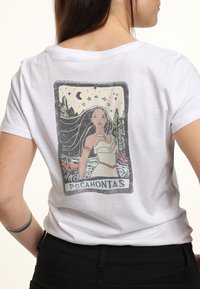 Biała bawełniana koszulka z grafiką w stylu vintage przedstawiającą Pocahontas na plecach, z szczegółowymi ilustracjami drzew, gwiazd i rzeki.