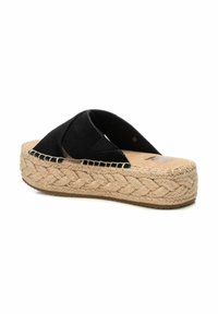 Sandalia deslizante de ante negro con suela de yute trenzada al estilo espadrille. Diseño de punta abierta y correas cruzadas. Plataforma texturada natural.