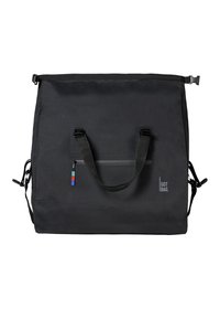 Černá textilní taška přes rameno s nastavitelnými uchy, přední kapsou na zip a vícbarevným ozdobným štítkem. Má minimalistický design.