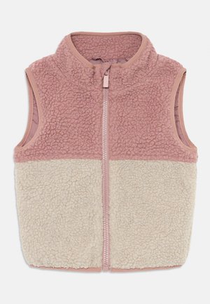 Gilet en polaire avec un col montant, présentant une partie supérieure rose pâle et une partie inférieure crème, fermeture zippée et sans manches.