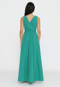Abito maxi turchese con scollatura a V sul retro, vita arricciata con elastico, gonna fluente e tessuto morbido.