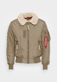 Giubbotto bomber color khaki con un colletto soffice bianco, chiusura con zip, polsini a coste e tasche laterali. Presenta un'etichetta rossa sulla manica sinistra.