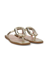 Sandalias planas metálicas doradas con grandes hebillas cuadradas y tiras tipo thong sobre suelas marrones, mostradas desde un ángulo frontal.