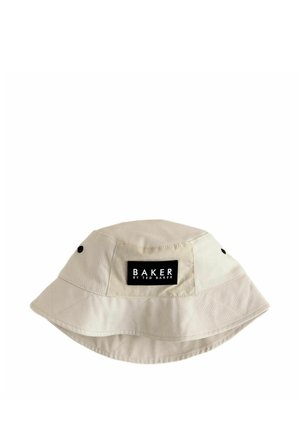 Chapeau bob beige avec un patch rectangulaire noir portant l'inscription "BAKER BY TED BAKER" sur le devant, avec de petits œillets noirs sur les côtés.
