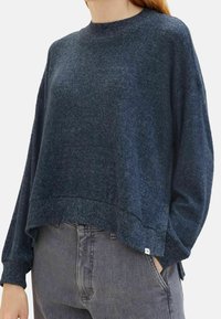 Tummansininen poolopaita pyöreällä pääntiellä, väljällä istuvuudella ja resoröidyillä hihoilla. Pehmeä rakenne, jossa on liukuvärjäys ja pidempi selkäosa.