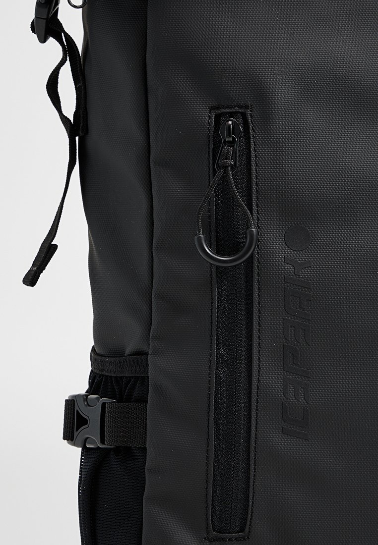 Czarny plecak z teksturowanej tkaniny, kieszenią na zamek, regulowanym paskiem i markowym akcentem. Strukturalny design z minimalistycznymi cechami.