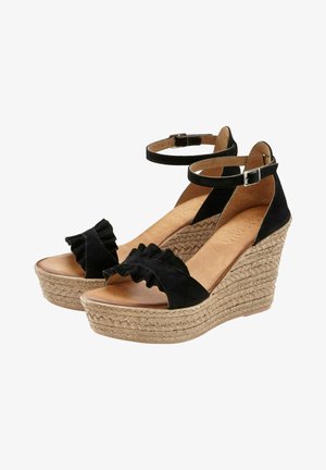 Sandalias de cuña de ante negro con correas alrededor del tobillo, bandas delanteras con volantes y suelas plataforma de fibras naturales trenzadas.