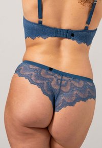 Lace lingerie set in donkerblauw, met een bralette met golvende rand en verstelbare bandjes, en bijpassende kanten hipsterpanty's.