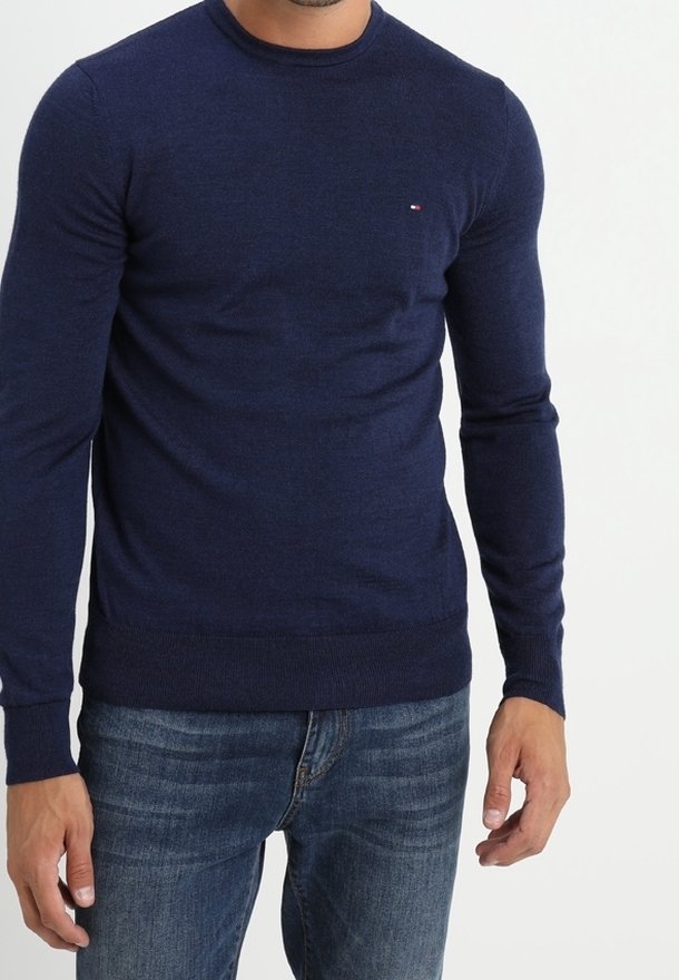 Marinblå stickad tröja med rund halsringning och långa ärmar. Har en liten logotyp på bröstet samt ribbade manschetter och nederkant. Bärs med jeans.