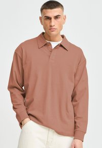 Langærmet polo shirt i støvet rosa farve, med knaplukning, fold-over krave og afslappet pasform, lavet af glat bomuldsstof.