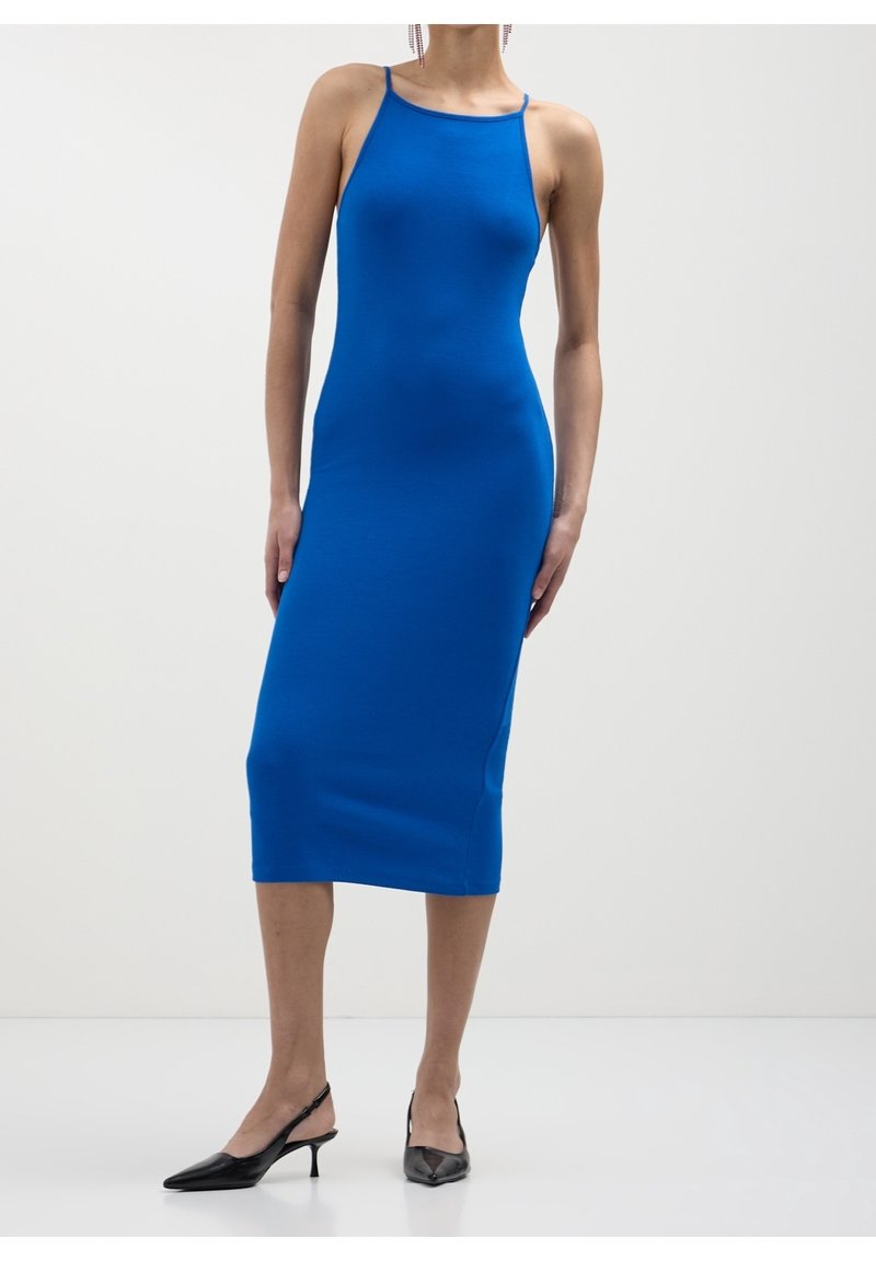 Robe midi bleu ajustée avec fines bretelles, confectionnée dans un matériau lisse et élastique. Accompagnée de talons slingback noirs à bout pointu.