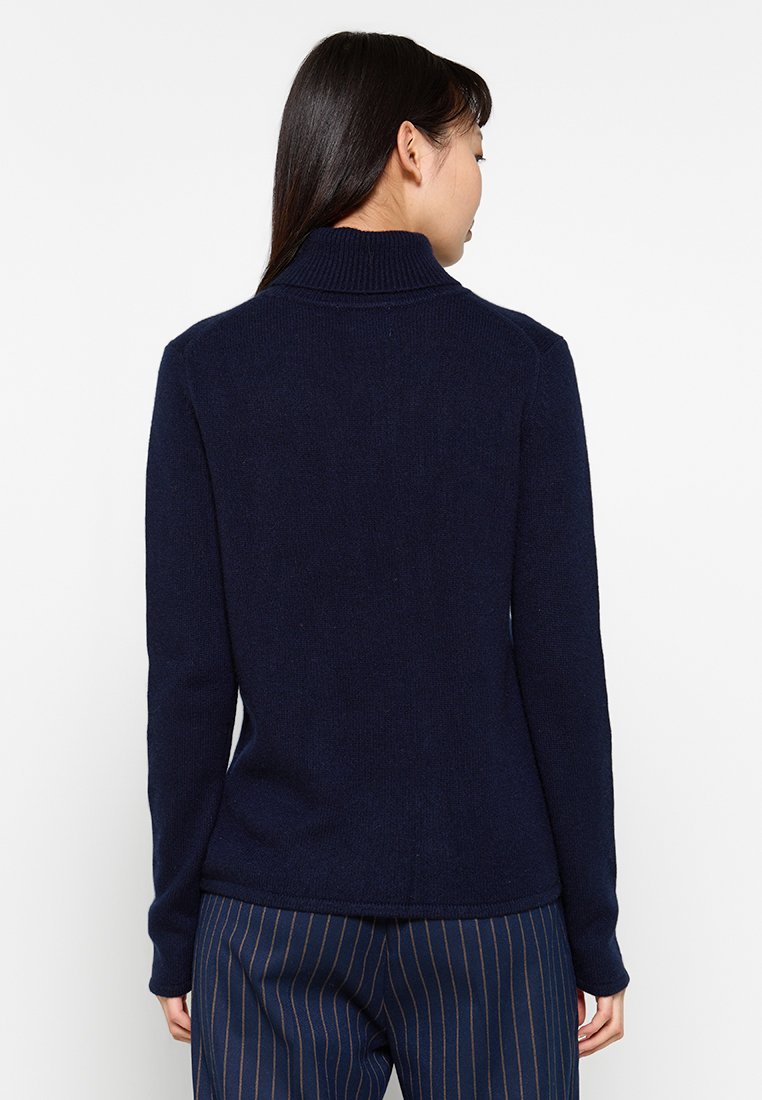 Marineblauer Pullover mit hohem Kragen, aus weichem Strickstoff gefertigt. Bietet eine taillierte Silhouette und lange Ärmel, mit einer glatten Textur.