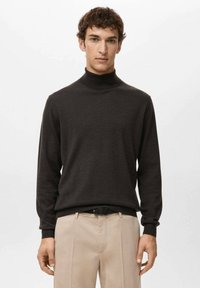 Ciemny golf z miękkiej tkaniny, dopasowany krój, długie r�ękawy, o gładkiej fakturze, zestawiony z jasnobeżowymi spodniami.