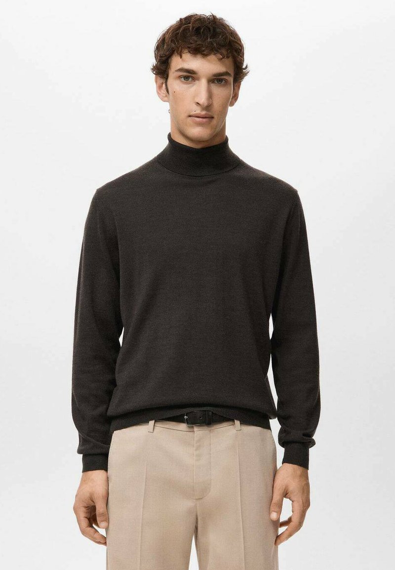 Ciemny golf z miękkiej tkaniny, dopasowany krój, długie rękawy, o gładkiej fakturze, zestawiony z jasnobeżowymi spodniami.